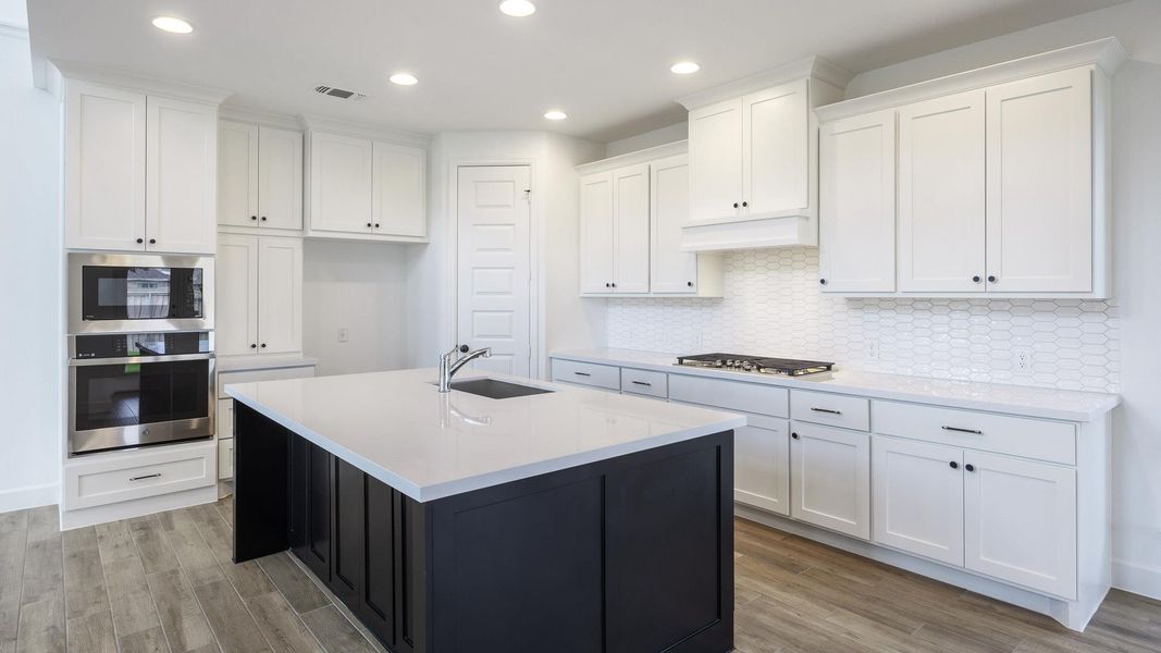 Kitchen featuring stainless steel appliances, light wood-style floors, white cabinets, tasteful backsplash, and recessed lighting Kitchen featuring stainless steel appliances, light wood-style floors, white cabinets, tasteful backsplash, and recessed lighting