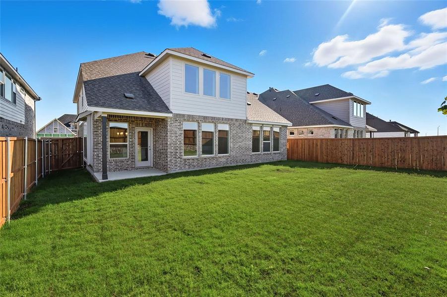 Back of house with a shingled roof, a patio, brick siding, and a fenced backyard Back of house with a shingled roof, a patio, brick siding, and a fenced backyard