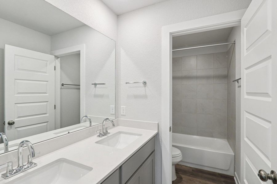 A secondary bathroom with adouble vanity and tub/showercombination—perfect for familyor guests. A secondary bathroom with adouble vanity and tub/showercombination—perfect for familyor guests.