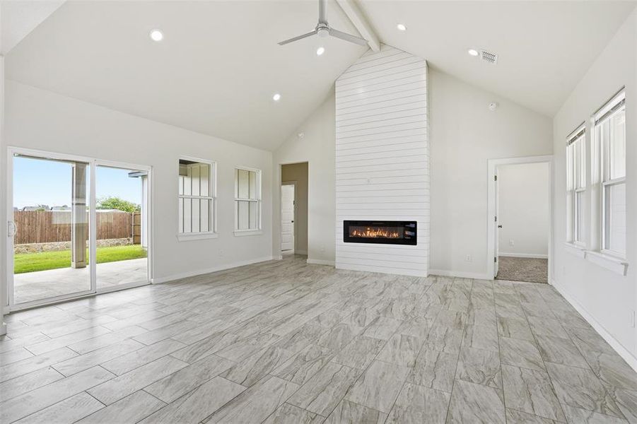 Spacious living area featuring a vaulted ceiling with a ceiling fan, recessed lighting, and tile flooring