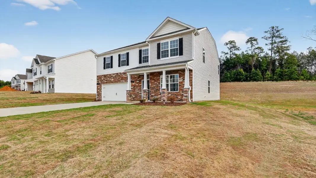 Front exterior of a new home in Shahbain Reserve, Raeford, NC, highlighting curb appeal (Image 2). Front exterior of a new home in Shahbain Reserve, Raeford, NC, highlighting curb appeal (Image 2).