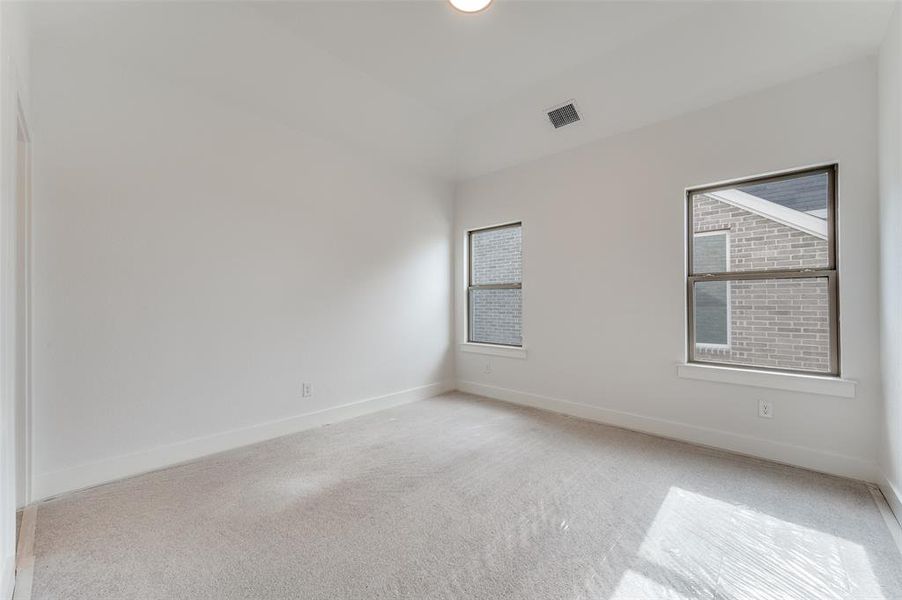 Empty room featuring light carpet