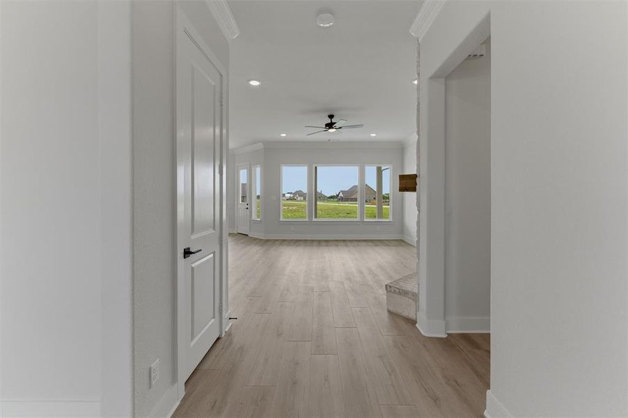 Expansive room featuring light wood-finish flooring, recessed lighting, and a ceiling fan