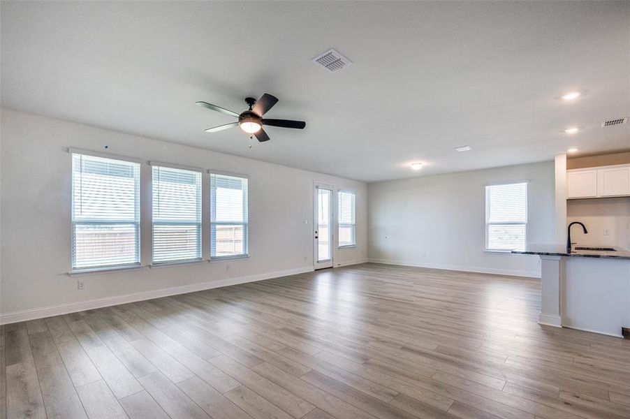 Unfurnished living room featuring a ceiling fan, light wood finished floors, and recessed lighting Unfurnished living room featuring a ceiling fan, light wood finished floors, and recessed lighting