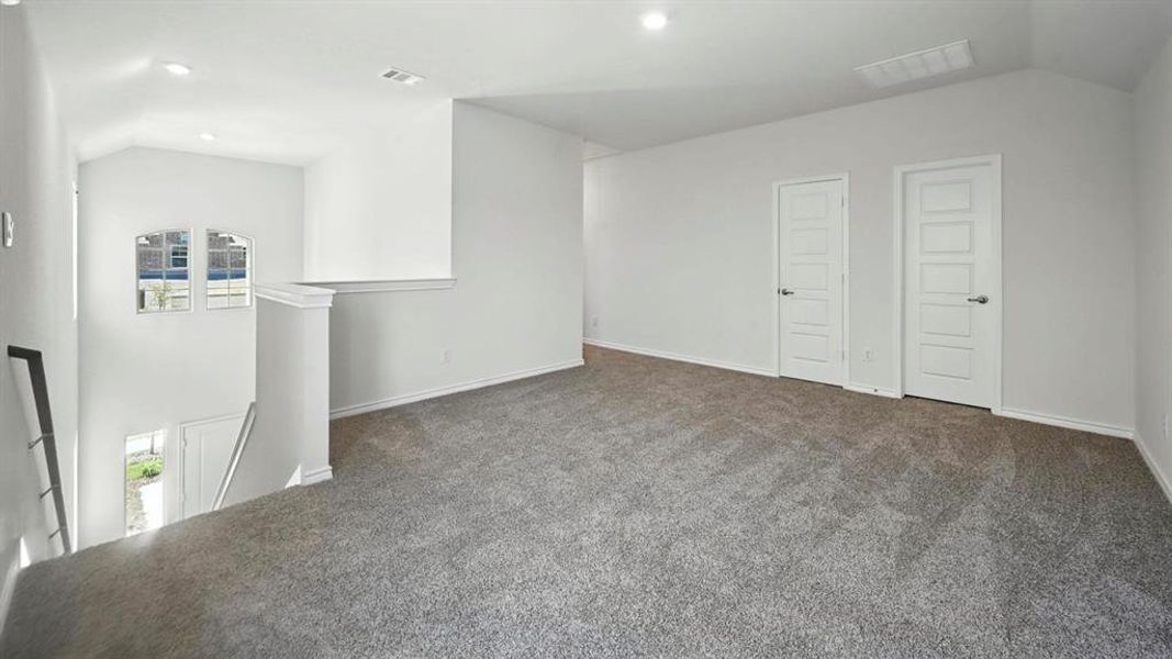 Carpeted empty room featuring vaulted ceiling and recessed lighting