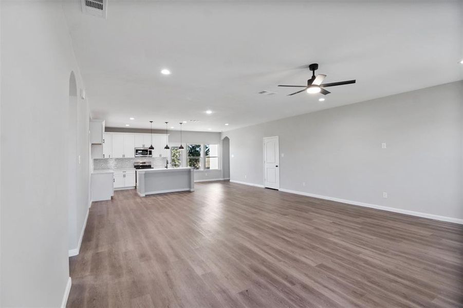 Unfurnished living room featuring ceiling fan and light hardwood / wood-style flooring