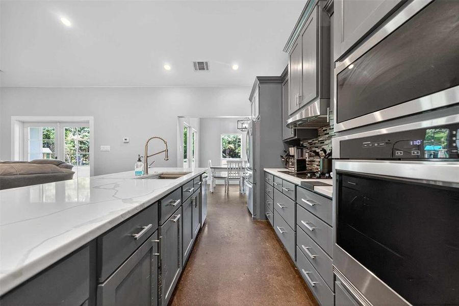Kitchen featuring appliances with stainless steel finishes, open floor plan, recessed lighting, plenty of natural light, and decorative backsplash Kitchen featuring appliances with stainless steel finishes, open floor plan, recessed lighting, plenty of natural light, and decorative backsplash