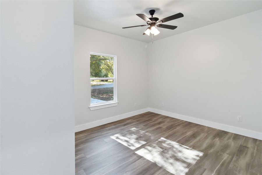 Unfurnished room with wood finished floors and ceiling fan