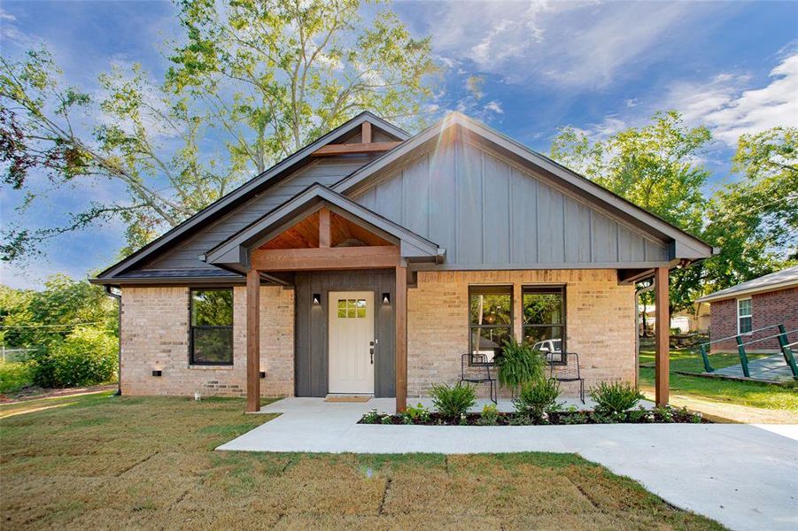 View of front facade featuring brick siding and board and batten siding View of front facade featuring brick siding and board and batten siding