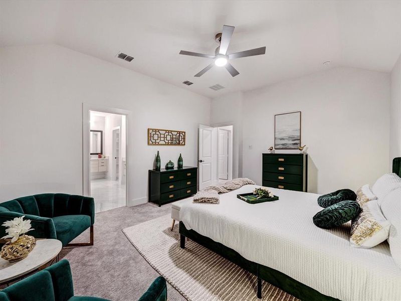 Carpeted bedroom with vaulted ceiling, ceiling fan, and ensuite bathroom Carpeted bedroom with vaulted ceiling, ceiling fan, and ensuite bathroom