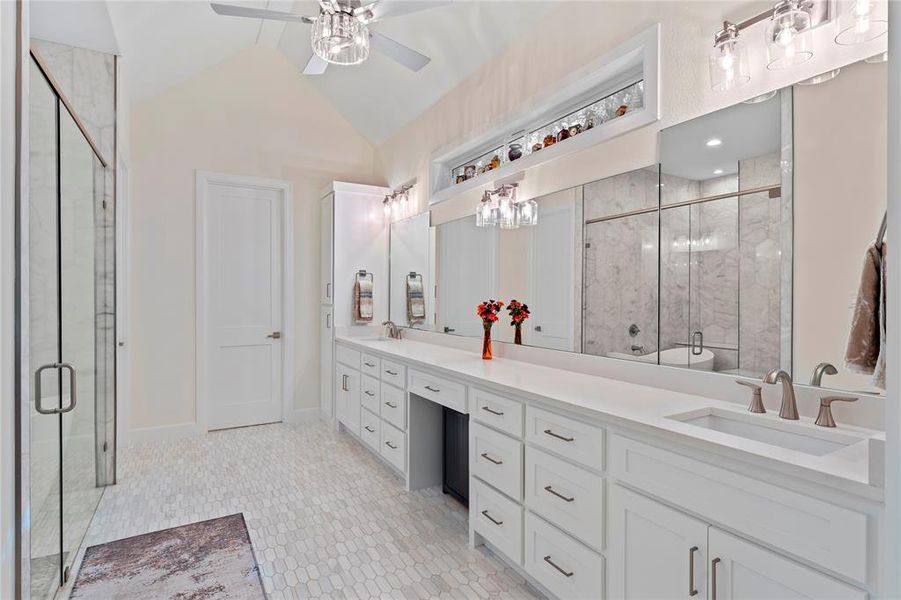 Bathroom with ceiling fan, vaulted ceiling, a shower with door, and vanity