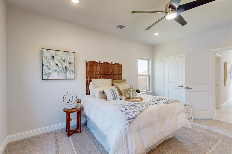 Main Carpeted bedroom with ceiling fan and a closet