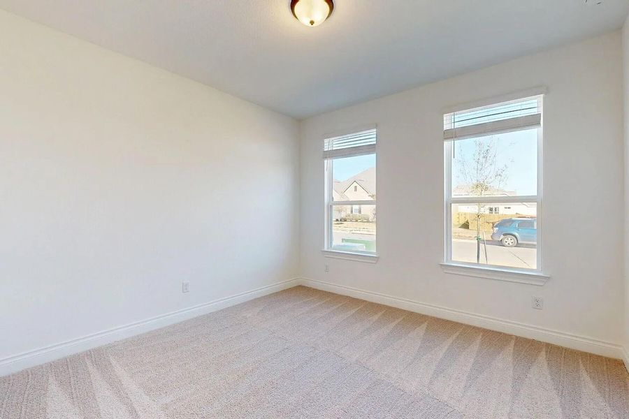 This room features two windows providing natural light, a neutral carpet, and white walls