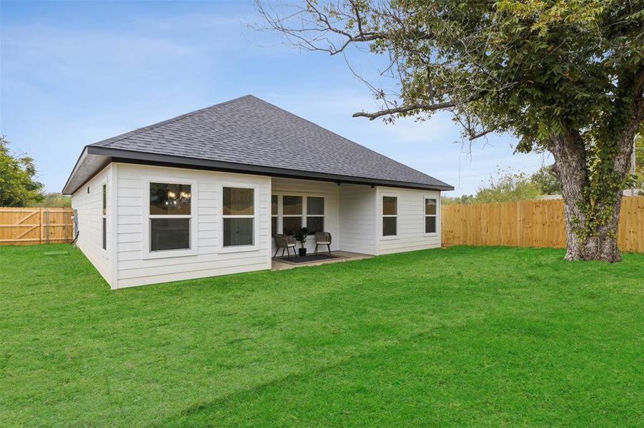 Back of house featuring a lawn and a patio