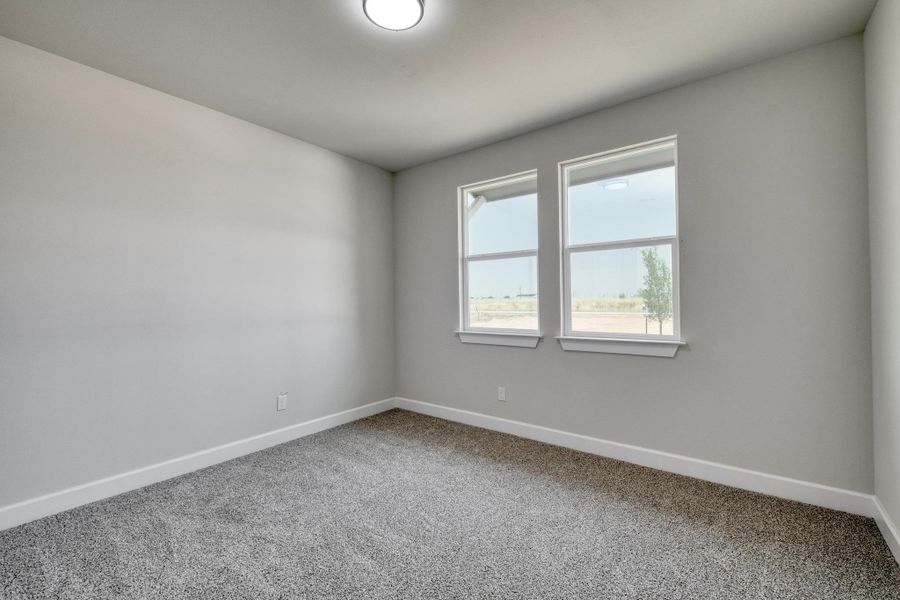 Spare room with carpet and baseboards