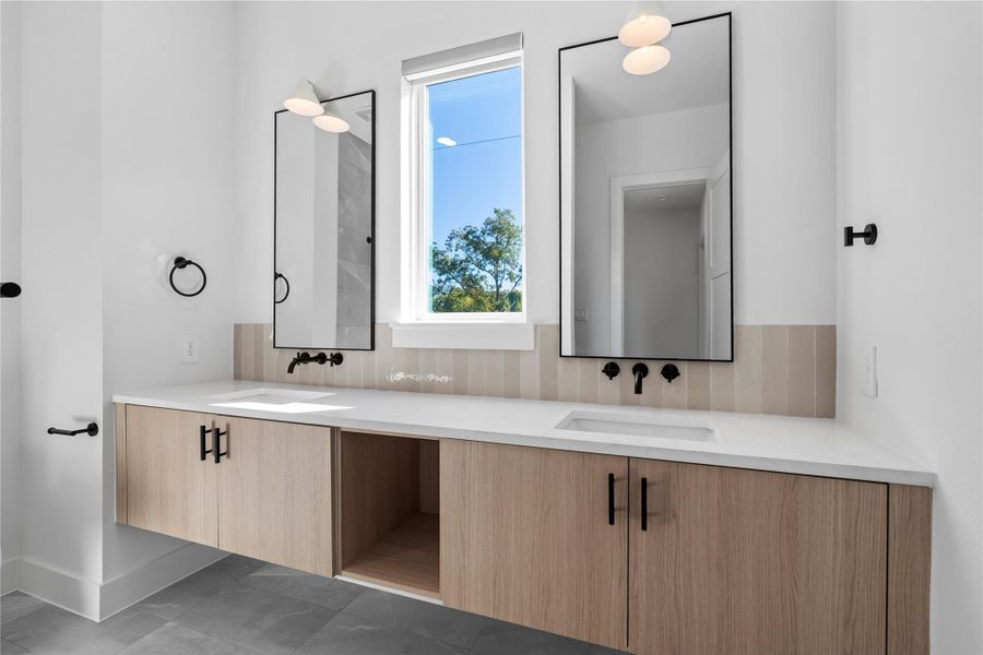 A balanced secondary bath designed for daily use, featuring a full tub and shower configuration paired with generous counter space and integrated storage.