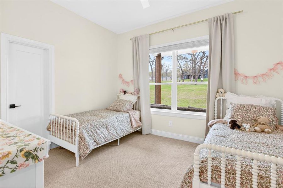 Bedroom featuring light carpet and a ceiling fan Bedroom featuring light carpet and a ceiling fan