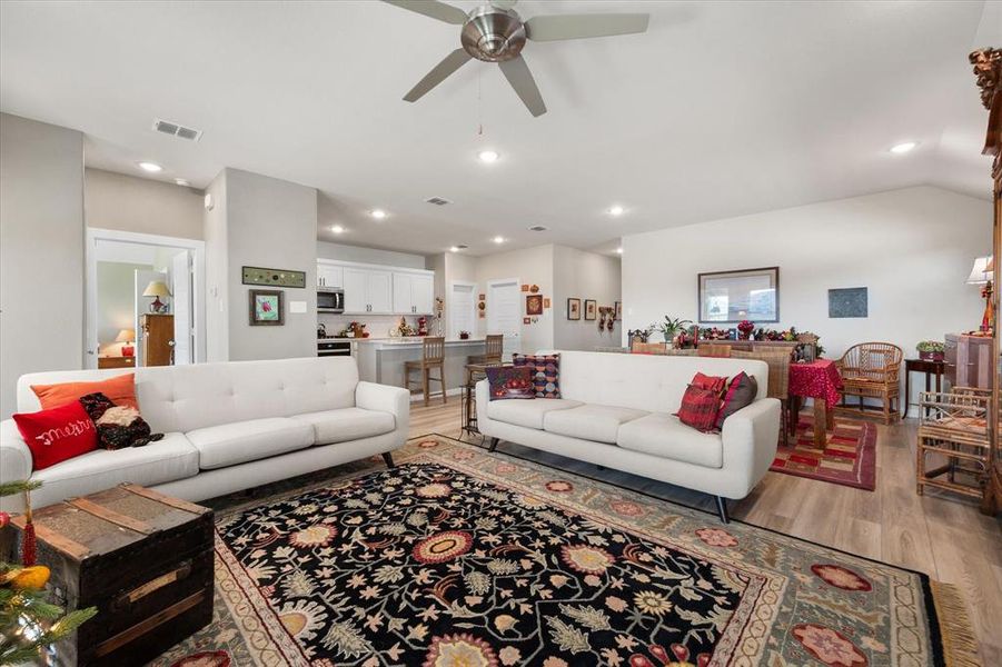 Living room with wood finished floors, recessed lighting, and a ceiling fan Living room with wood finished floors, recessed lighting, and a ceiling fan