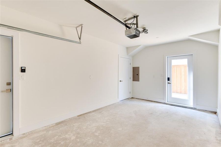 Garage featuring a garage door opener and electric panel