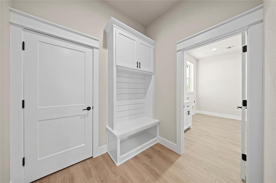 Mudroom with light wood-type flooring and baseboards