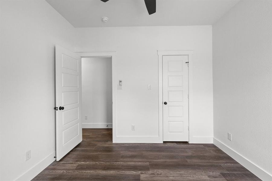 Unfurnished bedroom featuring ceiling fan and dark hardwood / wood-style floors