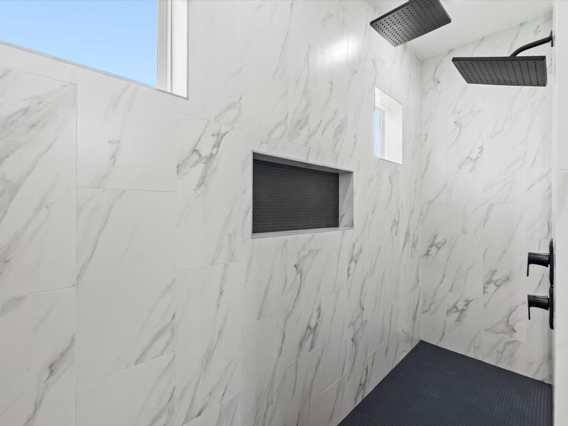 Primary bathroom shower with dual shower head and built in shelf. Primary bathroom shower with dual shower head and built in shelf.