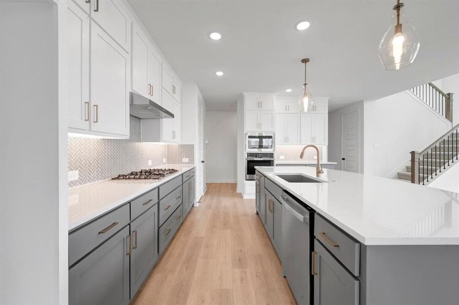 Modern kitchen featuring an expansive island with an undermount sink and integrated dishwasher