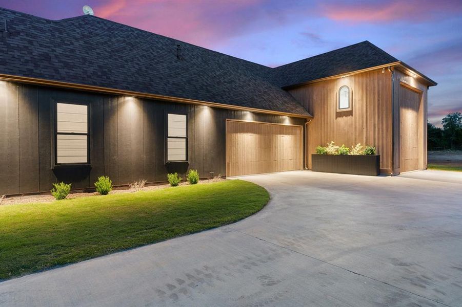 Contemporary home featuring a garage and a lawn