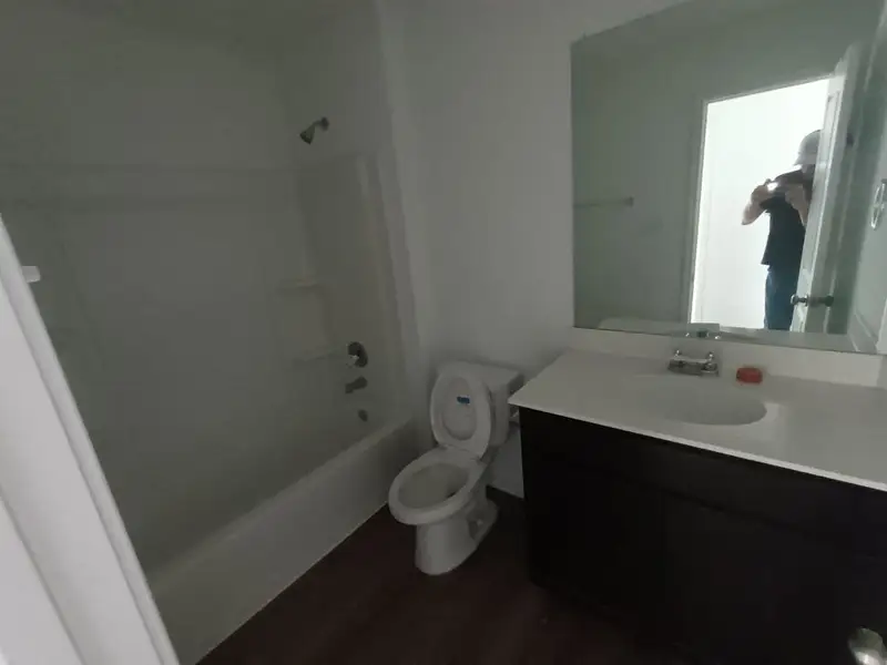 Full bathroom with shower / washtub combination, vanity, and dark wood-style flooring Full bathroom with shower / washtub combination, vanity, and dark wood-style flooring