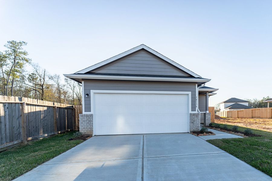 Front exterior of a new home in Caney Mills, Conroe, TX, highlighting curb appeal (Image 2).