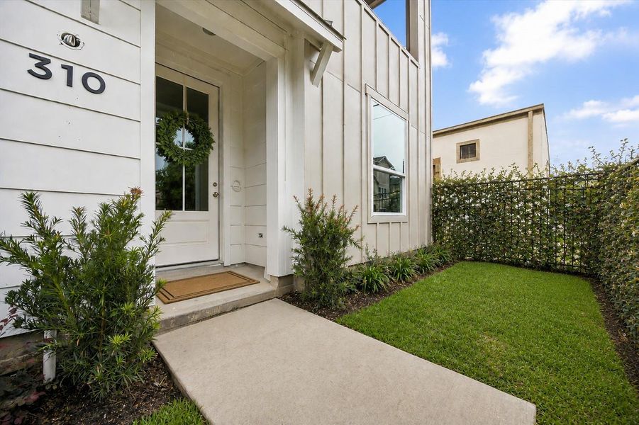 Alternate view of private fenced front yard with lush green space—perfect for pets, grilling or kids play. Mature privacy greenery digitally enhanced.