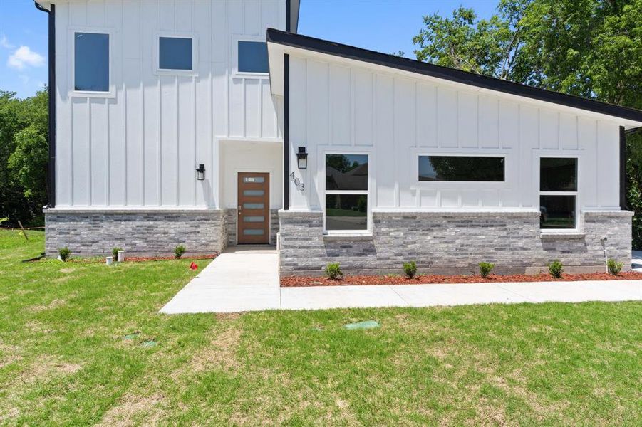 View of front of property featuring board and batten siding and a front yard View of front of property featuring board and batten siding and a front yard