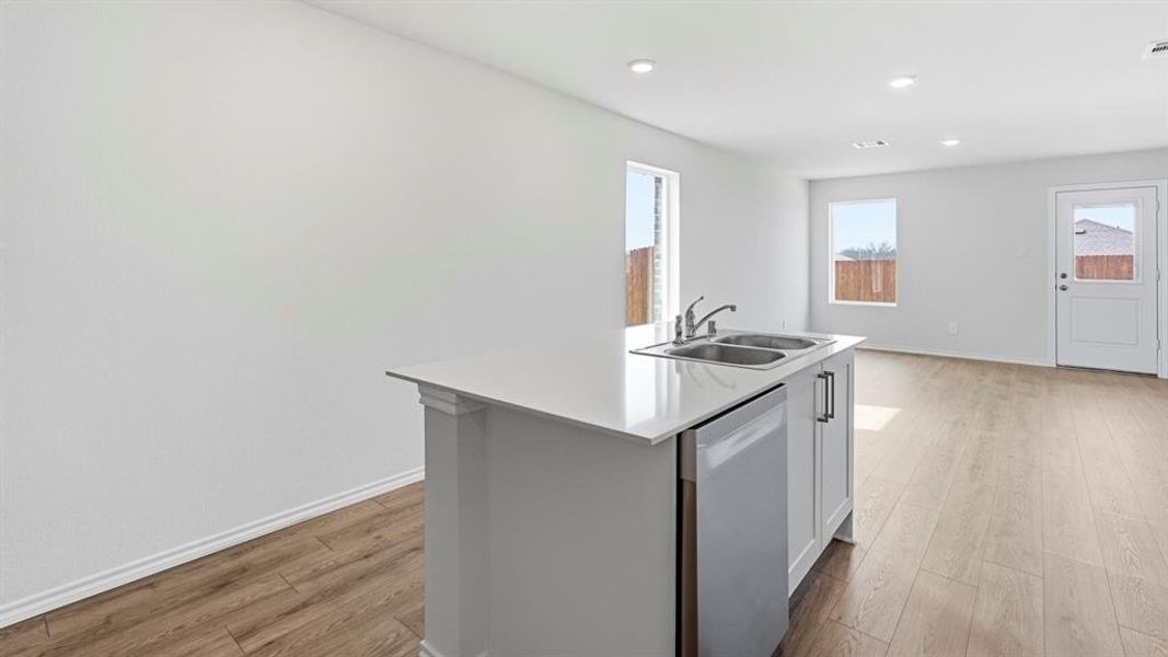 Kitchen featuring an island with sink, dishwasher, light wood finished floors, recessed lighting, and white cabinetry Kitchen featuring an island with sink, dishwasher, light wood finished floors, recessed lighting, and white cabinetry