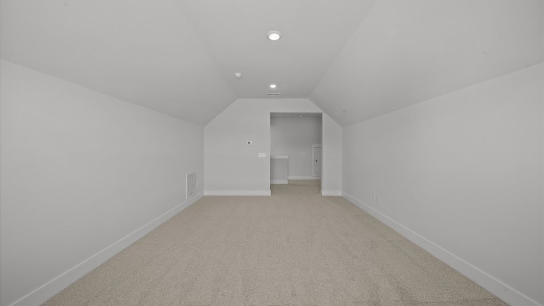 Inviting bonus room with cozy carpet, perfect for casual gatherings or quiet relaxation