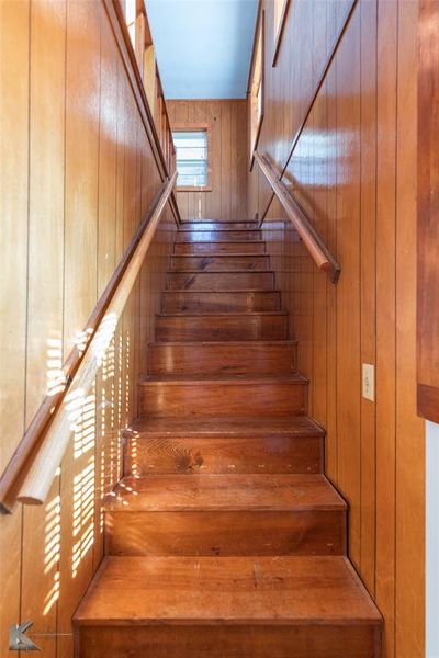 Staircase featuring wooden walls Staircase featuring wooden walls