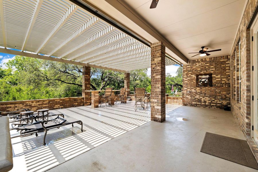 An inviting covered patio featuring brick pillars and lush natural views provides ample space for relaxation. An inviting covered patio featuring brick pillars and lush natural views provides ample space for relaxation.