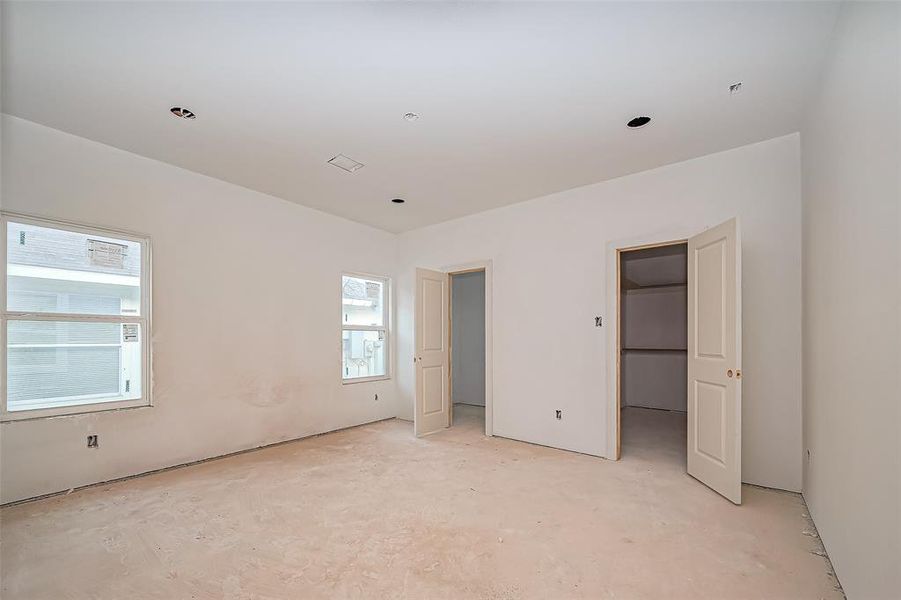 The primary bedroom is a standout space with large windows that promise abundant natural light. The expansive layout ensures room for a variety of furnishing possibilities. Includes a full entry closet for streamlined organization.