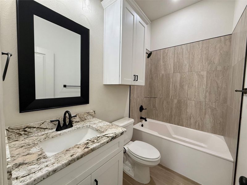 Bathroom featuring vanity, washtub / shower combination, and light wood-type flooring