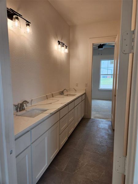 Bathroom with double vanity, tile patterned flooring, and ceiling fan