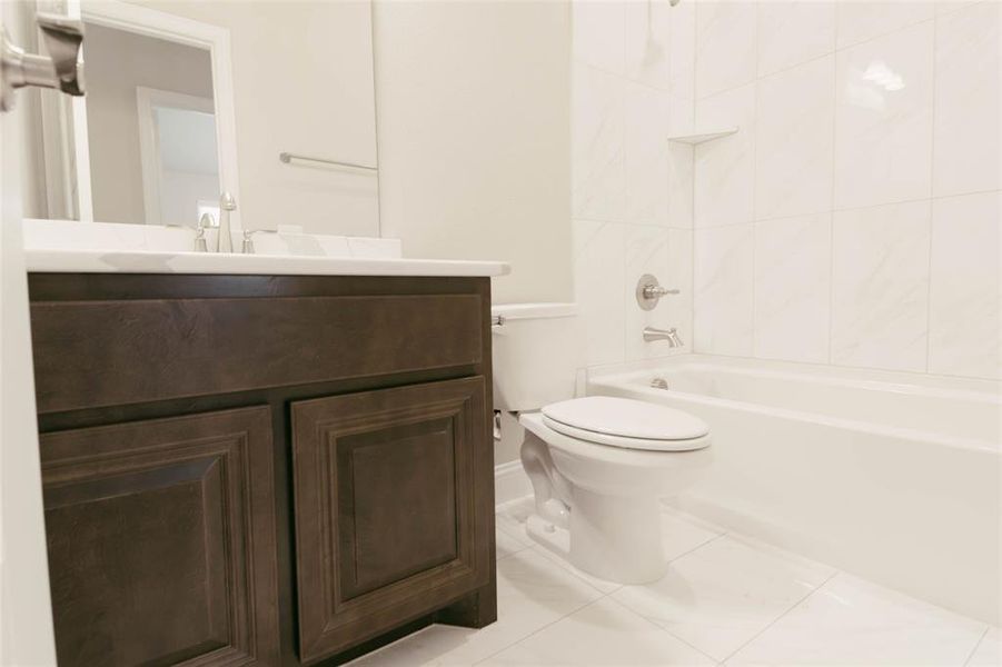 Full 2nd bathroom with vanity, toilet, tiled shower / bath combo, and tile patterned floors