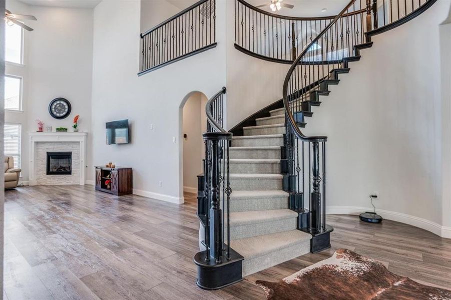 Stairway featuring ceiling fan, hardwood / wood-style flooring, and a towering ceiling