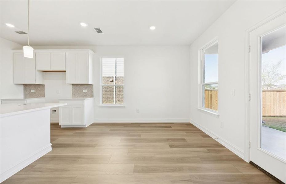 Dining nook off kitchen with large windows