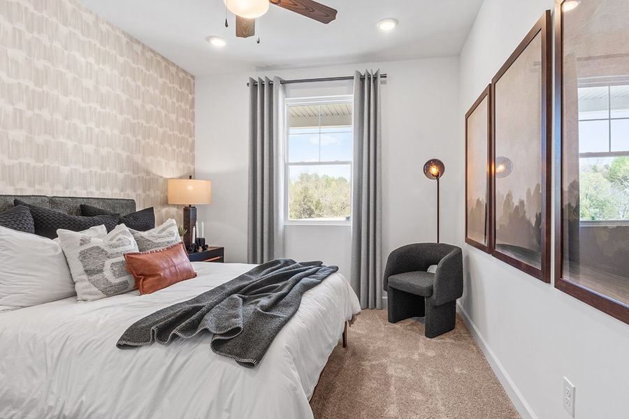 A bedroom with a bed and a chair. A bedroom with a bed and a chair.