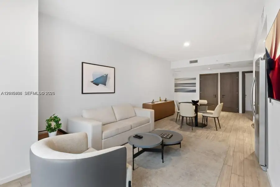 Open-concept interior featuring wood-finish flooring, recessed lighting, and dark-toned interior doors Open-concept interior featuring wood-finish flooring, recessed lighting, and dark-toned interior doors