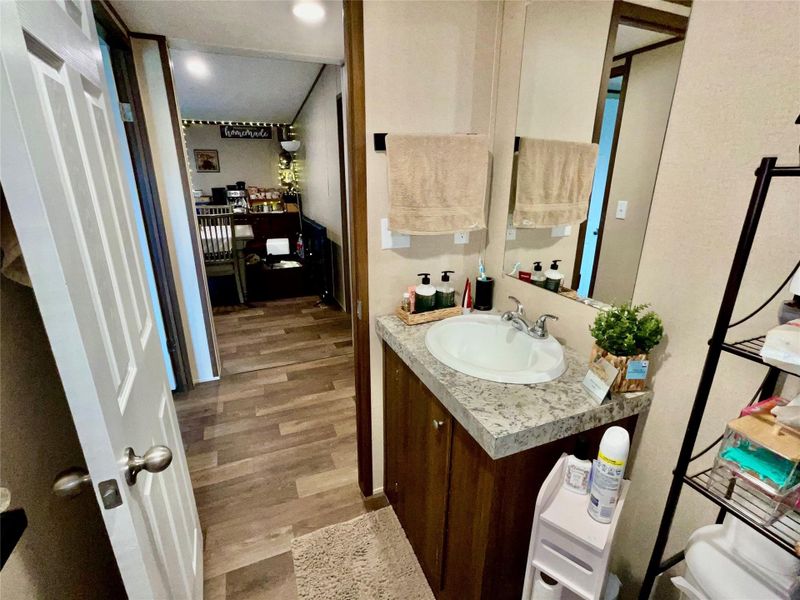 Vanity featuring a single oval sink, chrome faucet, and a light-colored speckled countertop