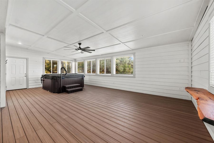 Wooden deck featuring a hot tub and a ceiling fan
