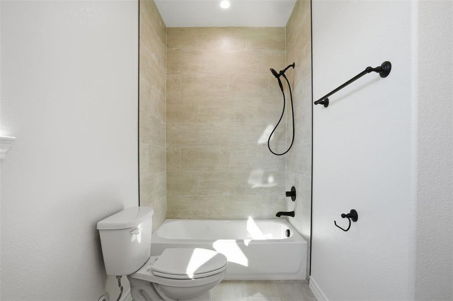 Bathroom featuring washtub / shower combination and toilet Bathroom featuring washtub / shower combination and toilet