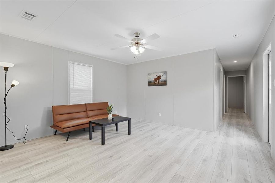 Sitting room with light wood-style floors and ceiling fan Sitting room with light wood-style floors and ceiling fan