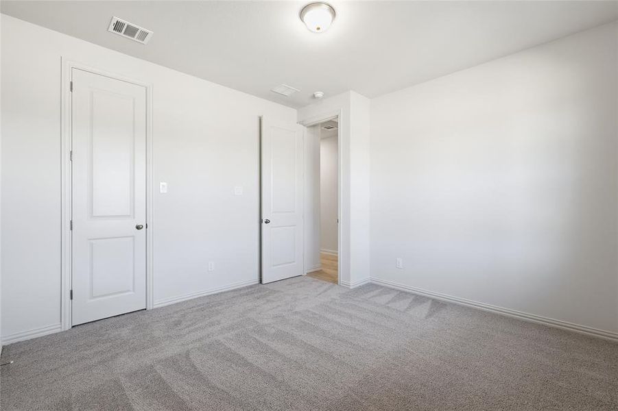 Unfurnished bedroom with carpet and baseboards