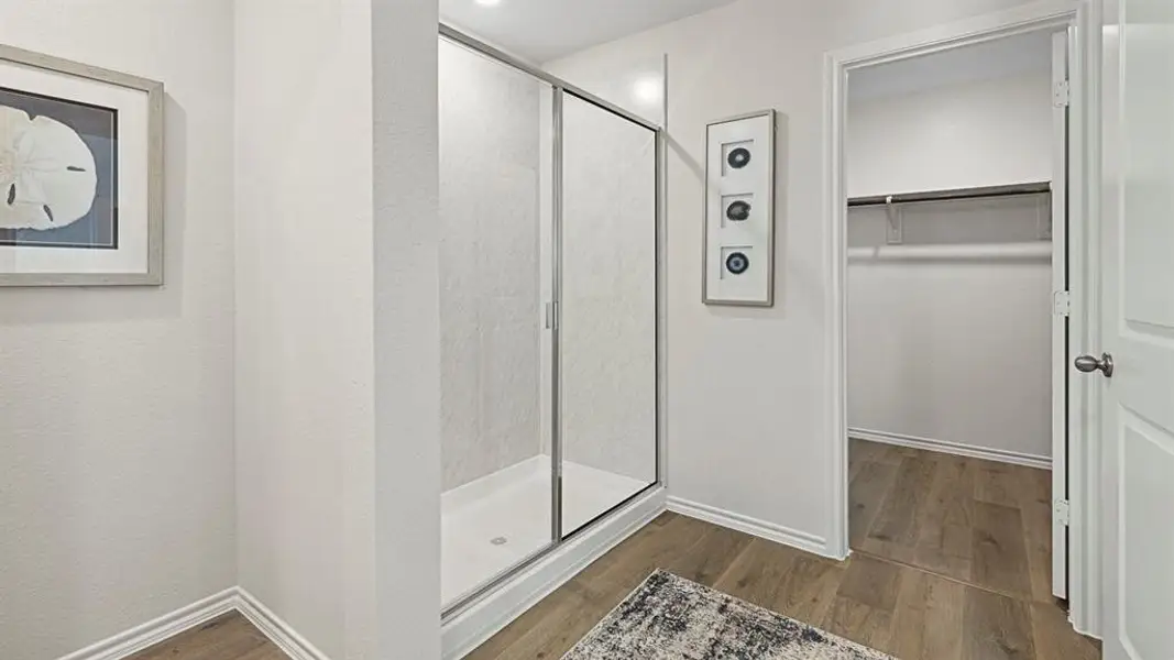 Bathroom with a shower stall, dark wood-type flooring, and a spacious closet Bathroom with a shower stall, dark wood-type flooring, and a spacious closet